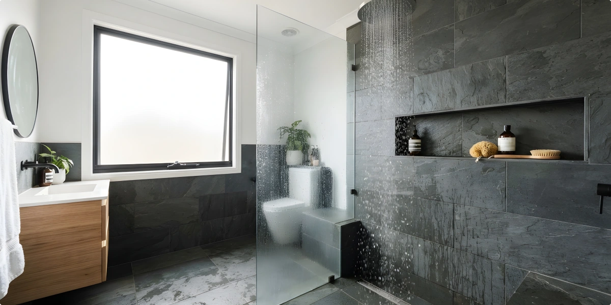 Baño moderno con revestimiento gris y ducha a ras de suelo