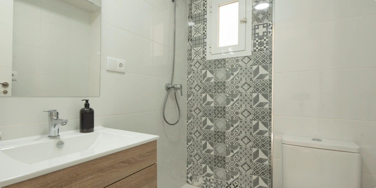 Revestimiento a media altura en un baño moderno con combinación de materiales