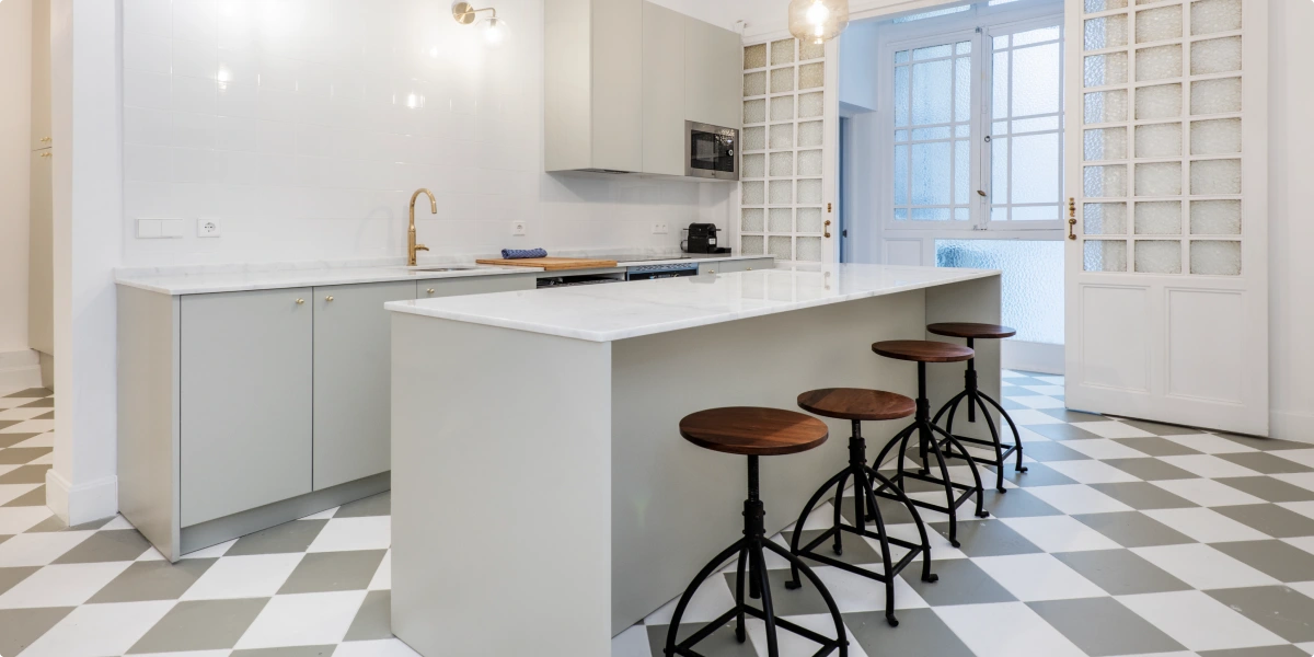 Barra que separa cocina y comedor con suelo de porcelánico en formato grande