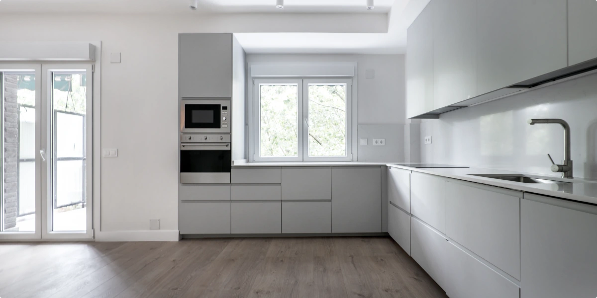 Cocina moderna pequeña en L con frontal claro y suelo continuo